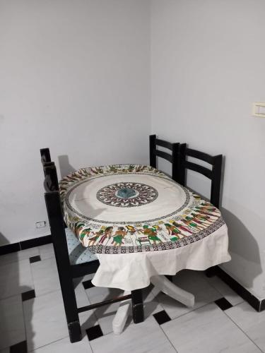 a chair with a table with a quilt on it at شاليه في المعموره in Alexandria