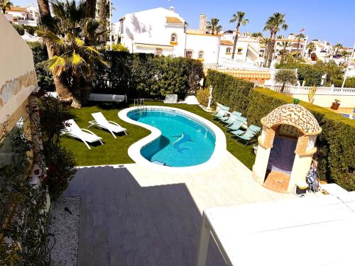 a backyard with a swimming pool and lounge chairs at Holiday VILLA GOLF & SEE VIEW Villamartin in Orihuela Costa