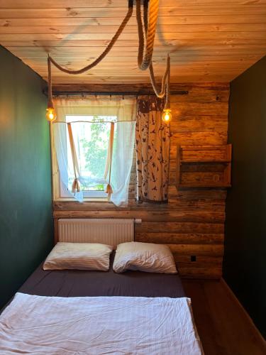 a bed in a room with a window at Chatka Wagabundy in Wola Michowa