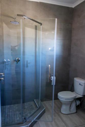 a bathroom with a glass shower with a toilet at Serene Stay Guesthouse in Letlhakane