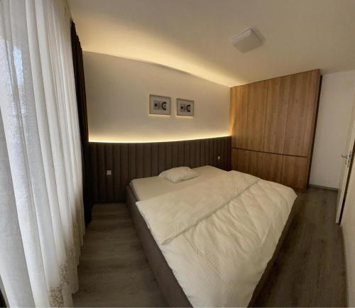 ein kleines Schlafzimmer mit einem weißen Bett darin in der Unterkunft Qendër in Ferizaj