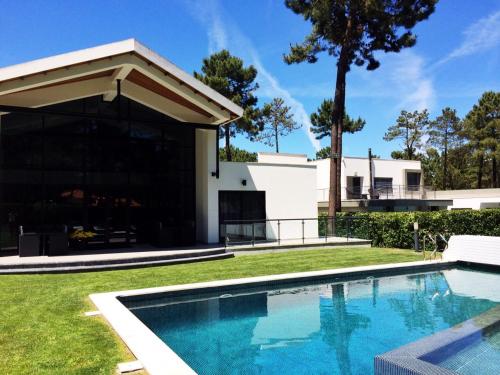 a swimming pool in front of a house at BelArt Luxury Golf Villa in Aroeira