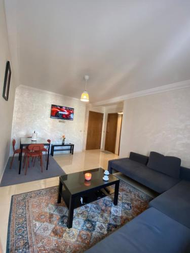 een woonkamer met een blauwe bank en een tafel bij Riad dari in Skhirat