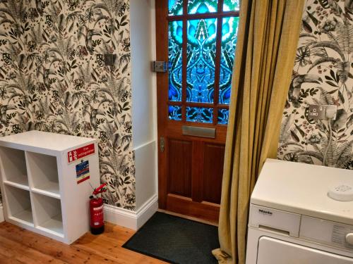 a small kitchen with a door and a window at Quaint 3 bedroom Devon cottage in Honiton