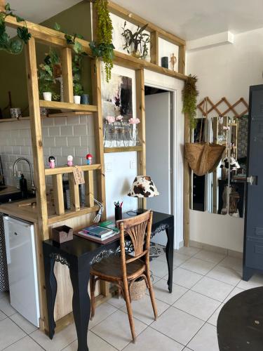 uma cozinha com uma mesa e uma secretária com uma cadeira em Charmant studio sur la Venise provençale 32m2 em Martigues