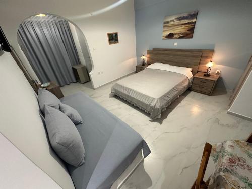 a bedroom with a bed and a couch at Studio Mare in Megalochori