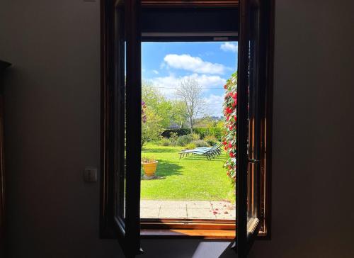 una ventana con vistas a un patio con un banco a través de él en Maison Croas Zellour, en Ploubazlanec