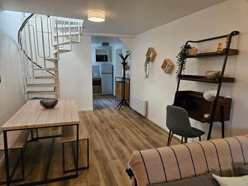un salon avec un canapé et un escalier en colimaçon dans l'établissement Charmant Duplex au cœur de Vernon proche gare et Giverny, à Vernon