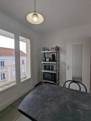 une pièce avec une table et deux chaises et une fenêtre dans l'établissement The place to be, parking gratuit, à Roanne