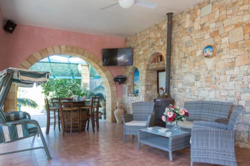 a living room with chairs and a stone wall at I SOGNI DI VENERE in Torre Suda