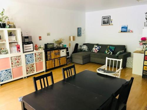 un salon avec une table et un canapé dans l'établissement Appartement jardin privatif, à Asnières-sur-Seine