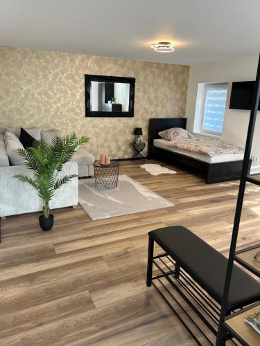 sala de estar con 2 camas y suelo de madera en Ferienwohnung Ambiente 1, en Naumburg