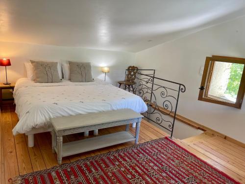 a bedroom with a large bed and a red rug at La Source in Rustrel