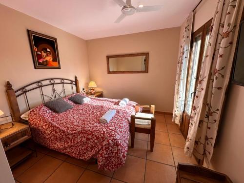 a bedroom with a bed with a red comforter at Posada La Fragua in Gandullas