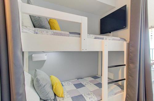 a room with a bunk bed with a television at 0510 Beachtrippin' home in Carolina Beach