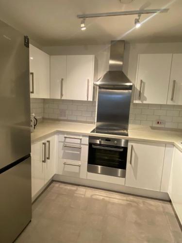 a kitchen with white cabinets and a stainless steel stove at Home Stay in Belvedere