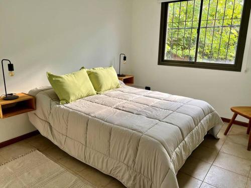 a bedroom with a large bed with a window at Luminoso departamento El Naranjo en Mendoza in La Cieneguita