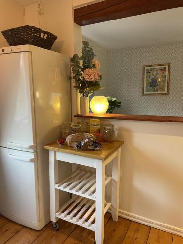a kitchen with a white refrigerator and a table at Bärsta Svit BnB in Kolbäck