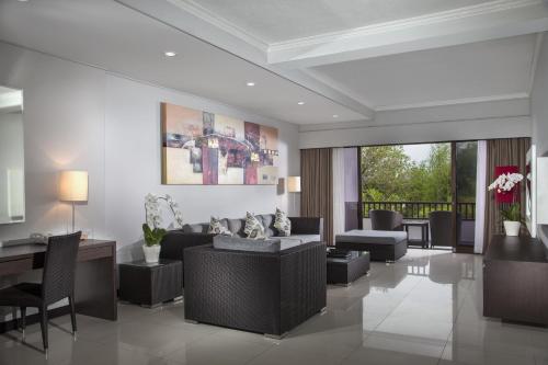 a living room with a couch and a table and chairs at Prime Plaza Suites Sanur – Bali in Sanur