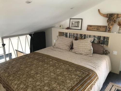 a bedroom with a large bed in a room at Cosy Studio Mezzanine 2 personnes Plage de Mardi Gras le Vieil in Le Grand Vieil