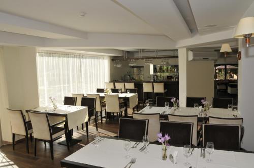 a dining room with white tables and chairs at Park Villa Hotel in Vilnius