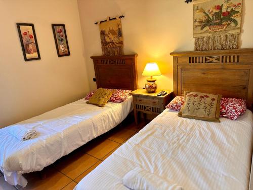 a bedroom with two beds and a night stand with a lamp at Posada La Fragua in Gandullas