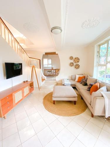uma sala de estar com um sofá e uma televisão em Millance volunteer hosting and safaris em Arusha