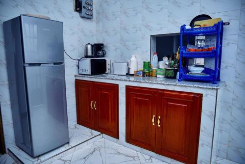 una cucina con armadi in legno e frigorifero in acciaio inossidabile di Millance volunteer hosting and safaris ad Arusha