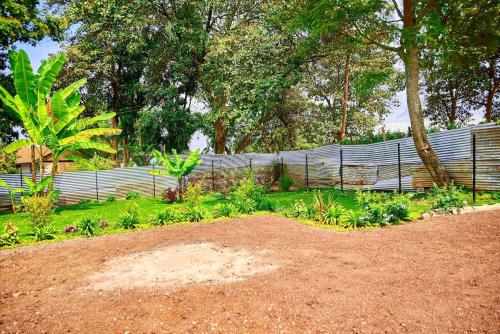 une clôture en face d'un jardin avec des plantes dans l'établissement Millance volunteer hosting and safaris, à Arusha