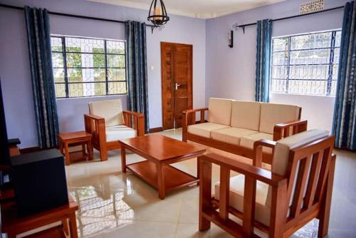 un soggiorno con divano e tavolo di Millance volunteer hosting and safaris ad Arusha