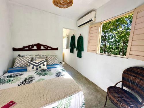 um quarto com uma cama e uma janela em Suíte - 05 em Gravatá