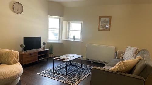 a living room with a couch and a tv at City Centre Bridge Street Apartment in Kirkwall