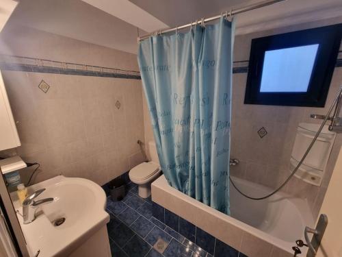 a bathroom with a toilet and a shower with a window at Agiokampos Harmony 1 in Agiokampos