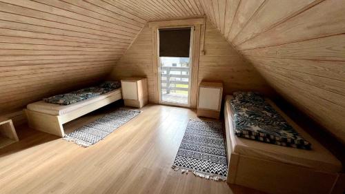 a attic room with two beds and a window at Domki wypoczynkowe LAS in Śliwice