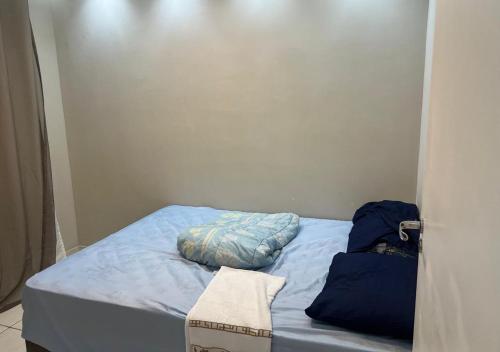 a small bed with blue sheets and pillows on it at Aeroporto Confins, 15min Belo-Horizonte, Cidade do Galo, Mega Space in Vespasiano