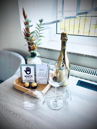 弗瓦迪斯瓦沃沃的住宿－Willa Aleksandra White Glove，一张桌子,上面放着一瓶葡萄酒和一杯