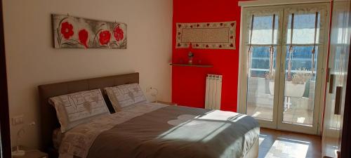 アオスタにあるLa Betulla Appartamento confortevole Wifi e Parking freeの赤い壁のベッドルーム1室(ベッド1台付)