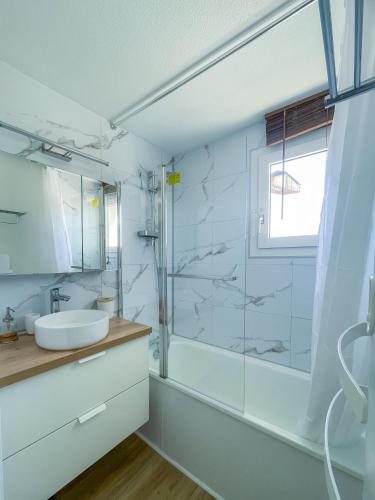 une salle de bain blanche avec un lavabo et une douche dans l'établissement Perle Bleu - Ravissant Logement Toulousain, à Toulouse