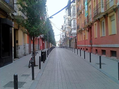 una bicicleta estacionada en una calle de ladrillo con edificios en Pisito del Sol en Santander