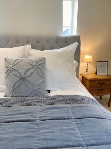 a bedroom with a blue and white bed and a table at Yarm Luxury Apartments - Bank House - private gated carpark in Yarm