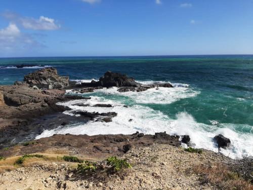 a beach with rocks and the ocean at Le Voyageur in Sainte-Marie
