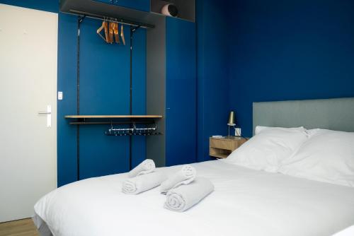 - une chambre bleue avec un lit et des serviettes dans l'établissement Perle Bleu - Ravissant Logement Toulousain, à Toulouse