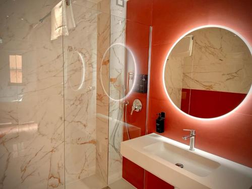 ein Bad mit einem Waschbecken und einer Dusche mit einem Spiegel in der Unterkunft Taormina Boutique Rooms in Taormina