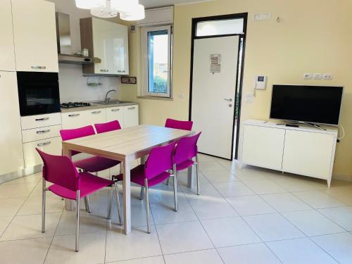 une cuisine avec une table en bois et des chaises violettes dans l'établissement APARTAMENT GARDEN-MARINA SVEVA, à San Salvo