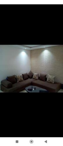ein Wohnzimmer mit einem braunen Sofa und einem Tisch in der Unterkunft Maison hergla in Sousse