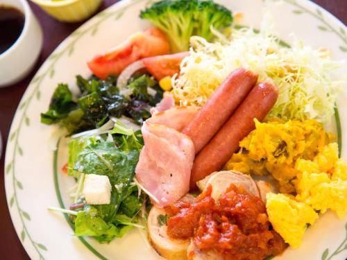 a plate of food with sausage and vegetables on it at Izuito Onsen Daitokan in Ito