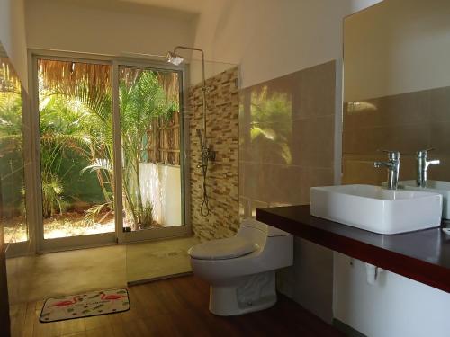 a bathroom with a toilet and a sink and a window at Zodiaco in Las Terrenas in Las Terrenas