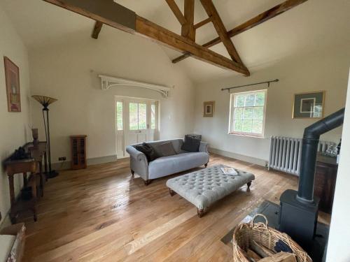 uma sala de estar com um sofá e um fogão em Apartment at Llanerchydol Hall em Welshpool