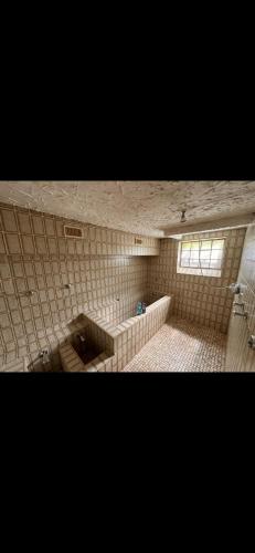 a tiled bathroom with a toilet and a window at Kellerwohnung inklusive Sauna für 2 in Recklinghausen