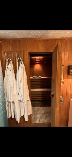 a closet with three white coats hanging on hooks at Kellerwohnung inklusive Sauna für 2 in Recklinghausen